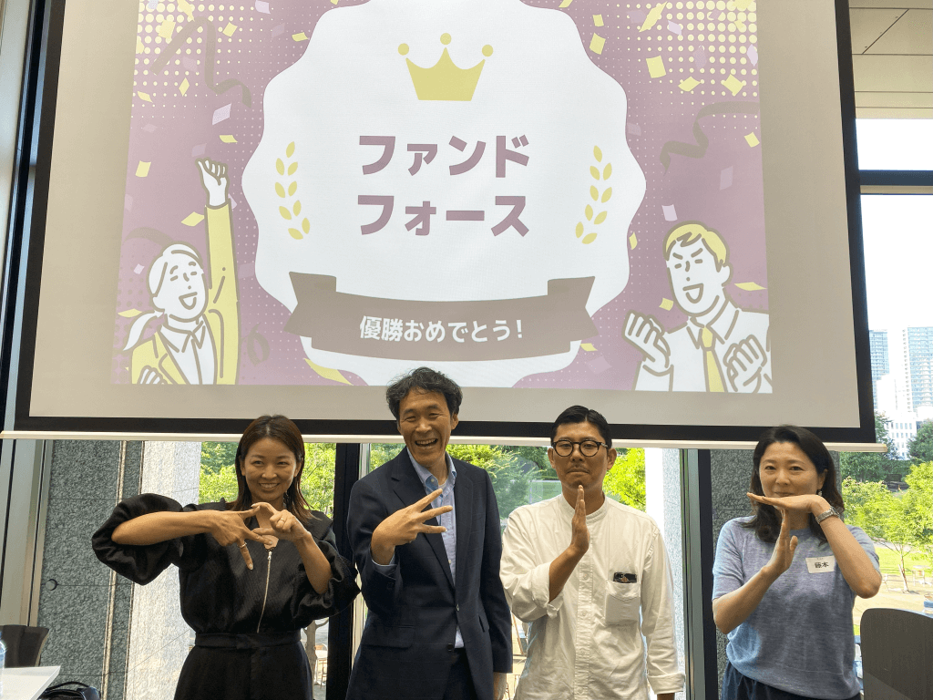 優勝チームであるファンドフォースのメンバーがそれぞれの手でREITの文字を形作って記念撮影をしている様子
